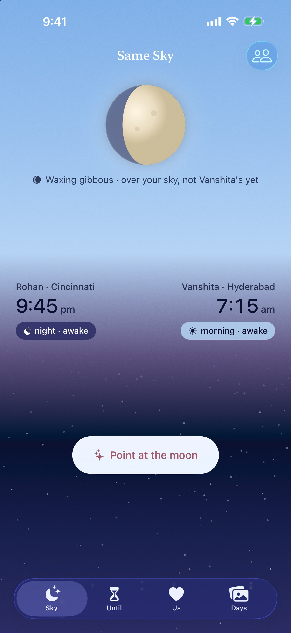 The Same Sky home screen. Vanshita's morning sky, pale blue, fills the top half with a waxing gibbous moon in it; Rohan's night sky, deep blue with stars, fills the bottom. Rohan in Cincinnati, 9:45 pm, night, awake. Vanshita in Hyderabad, 7:15 am, morning, awake. A Point at the moon button below.